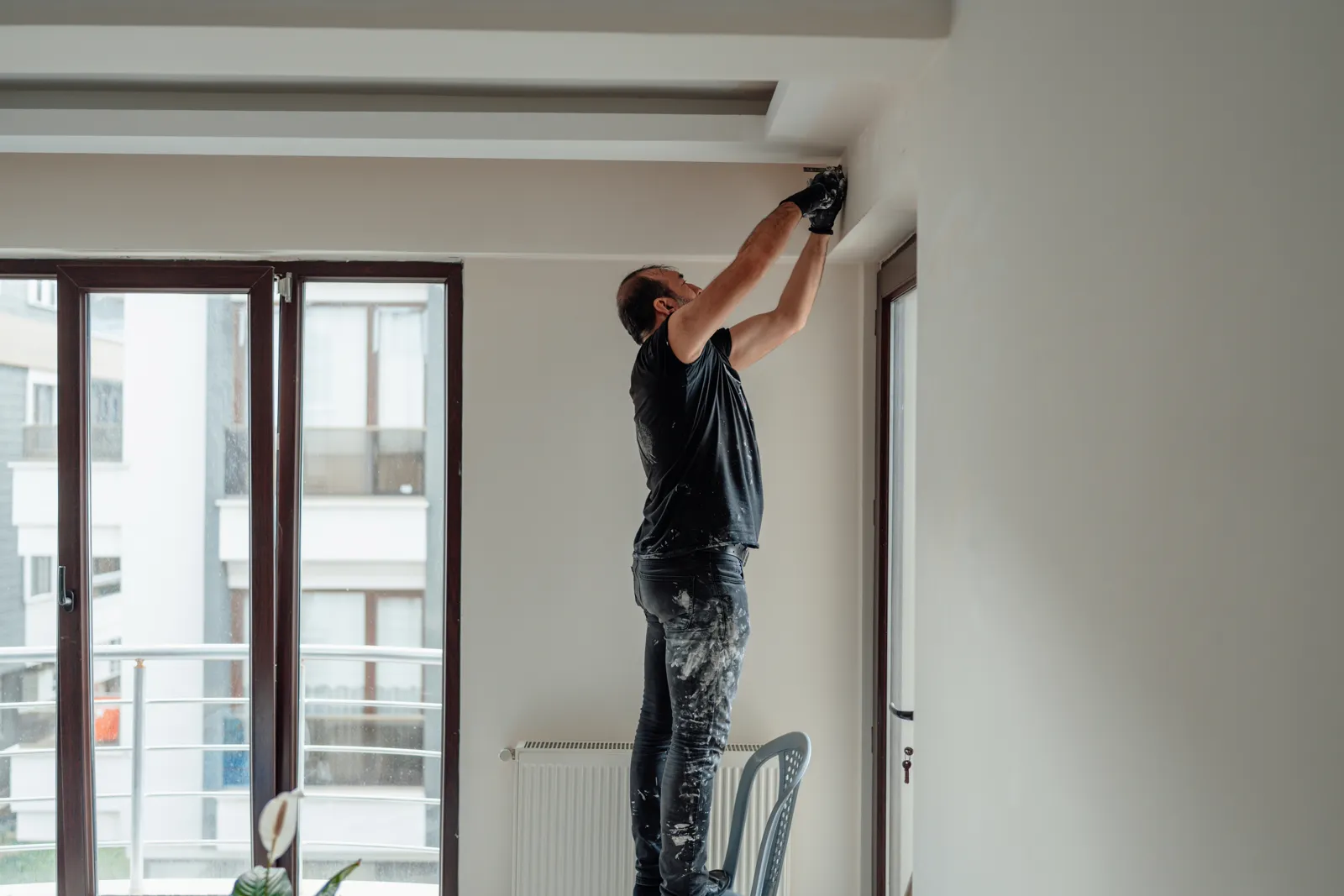 Painter on a ladder working on an interior wall